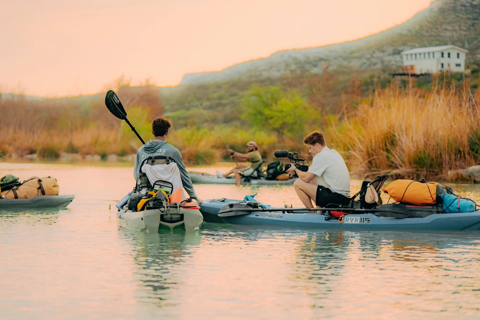 Luke Mayer filming from a kayak with the Dude Perfect Outdoors crew on Devil’s River