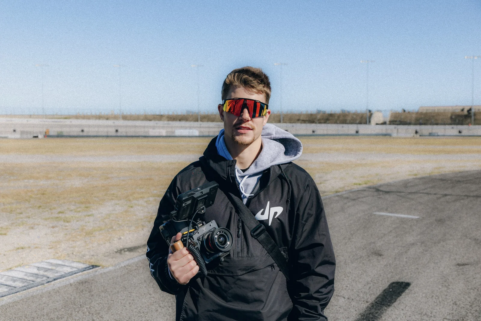 Luke Mayer with a cinema camera at a speedway